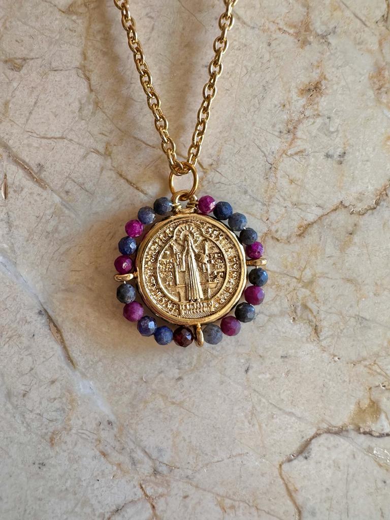 Medalla San Benito zafiro bañada en oro, con diseño religioso y halo de piedras azules, rojas y moradas

