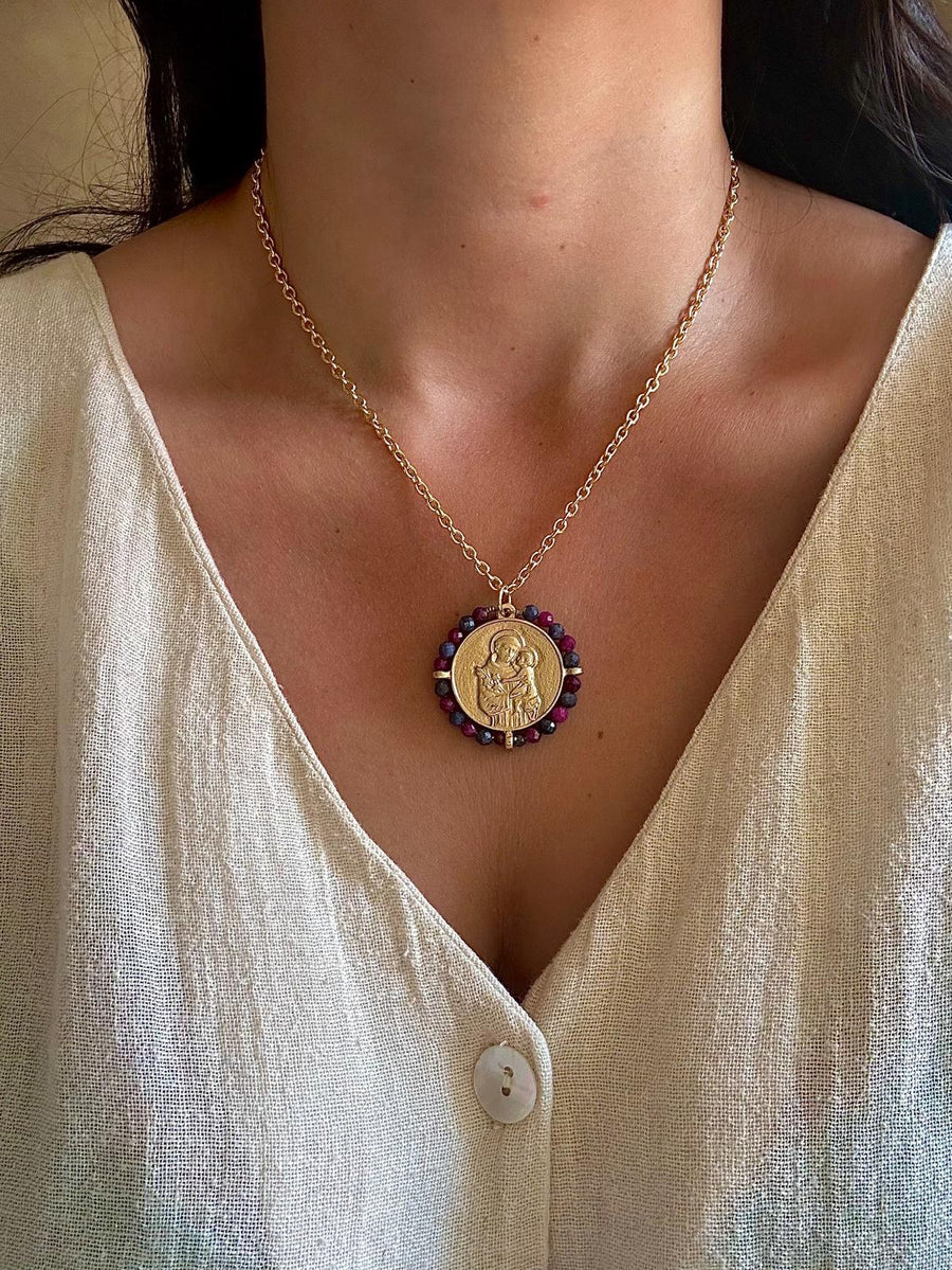 Medalla San Antonio con piedra fluorita dorada, con cadena fina y detalles circulares multicolor alrededor.