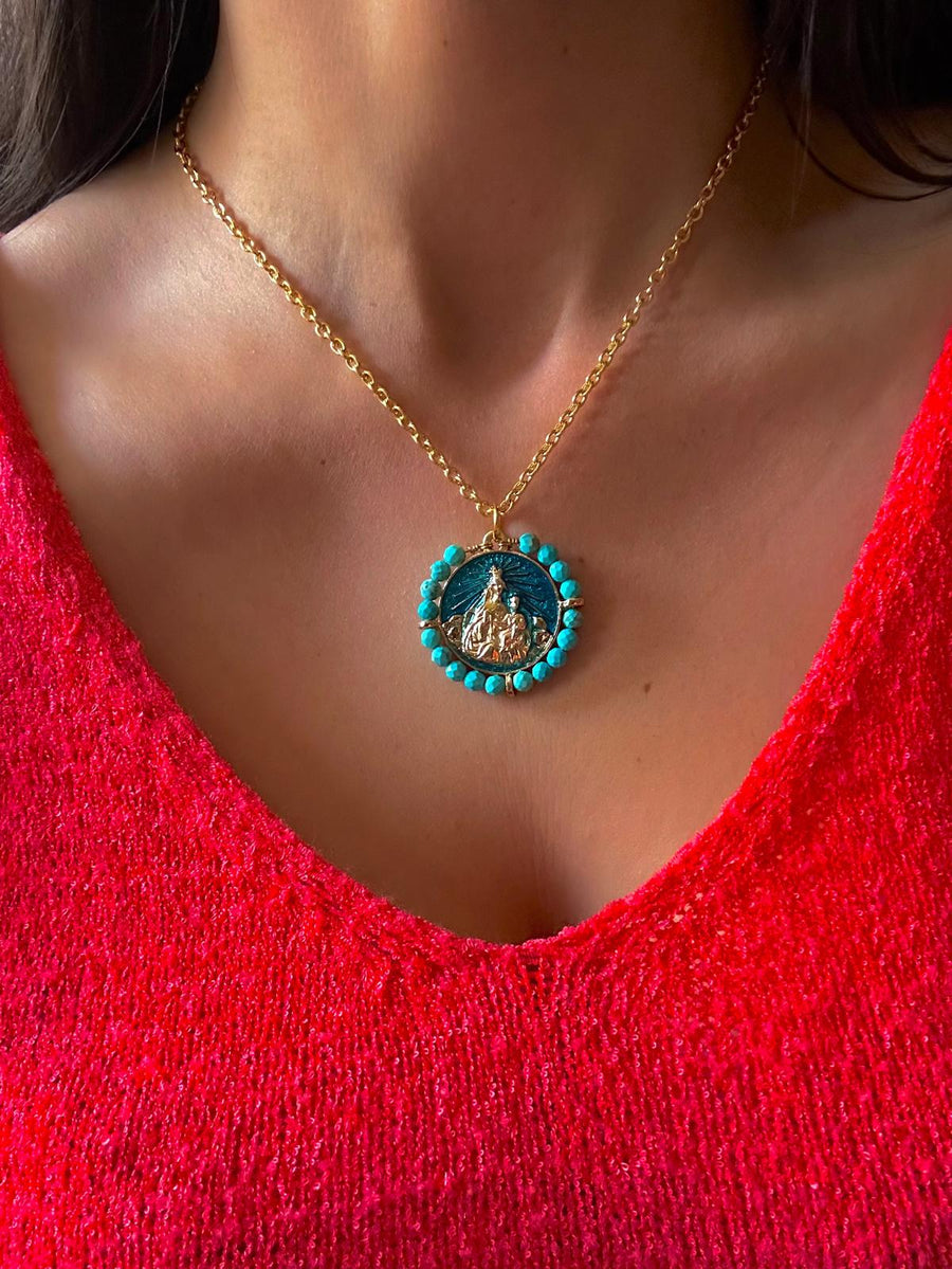 Medalla de la Virgen del Carmen con turquesas y esmalte turquesa puesta con jersey rojo