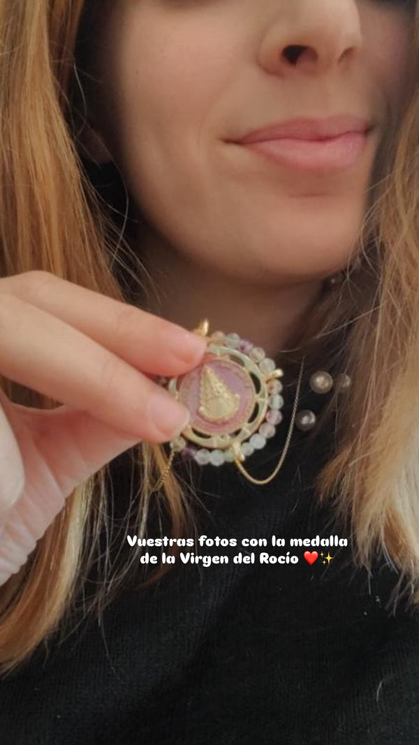 Medalla de la Virgen del Rocío Khartes en la mano de una clienta